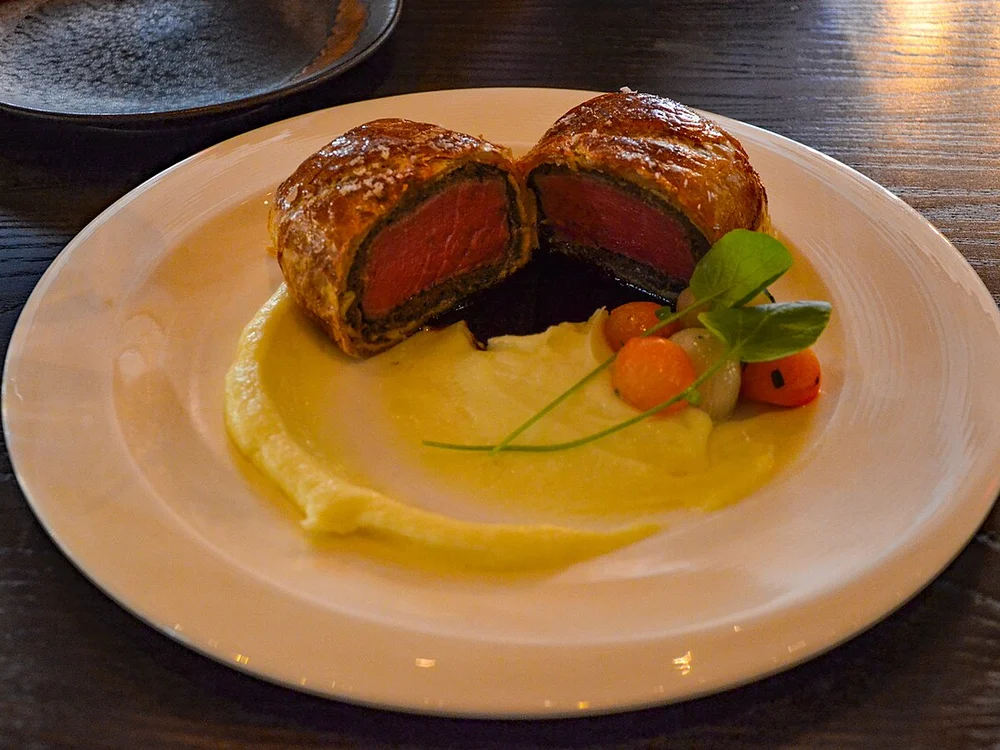 Signature golden puff-pastry Beef Wellington with potato purée and demi-glace